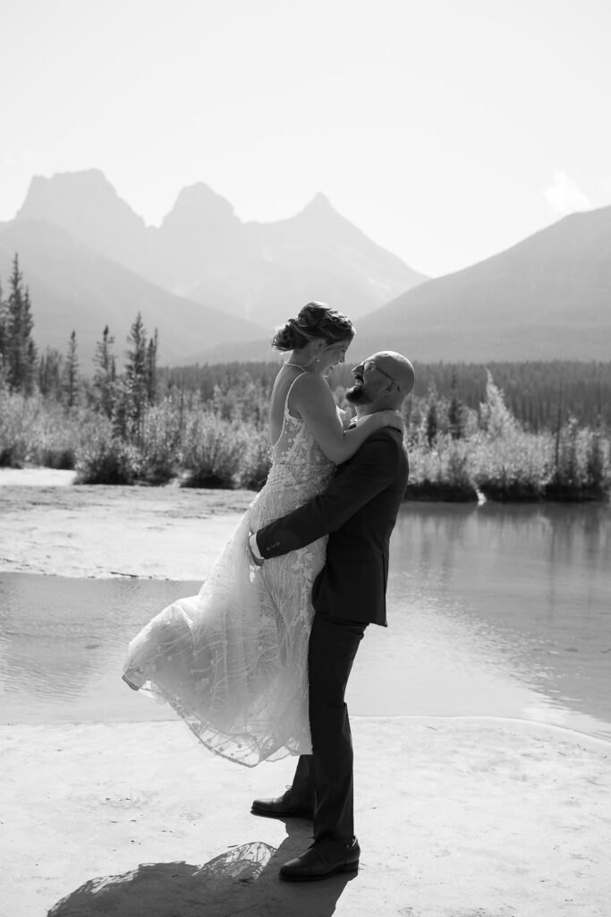 groom lifting up the bride with three sisters in the background